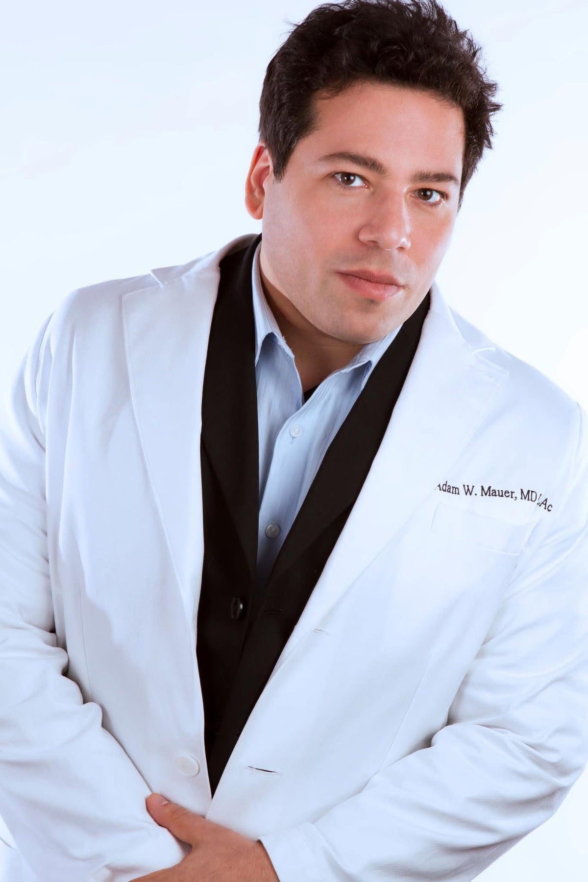 Adam Mauer, M.D. in a white coat with his name embroidered on the pocket.